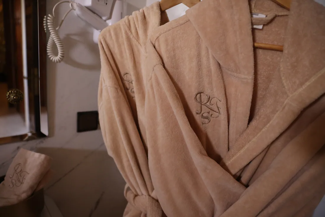 Monogrammed robes hanging ready in a marble bathroom at Riad Sebti.